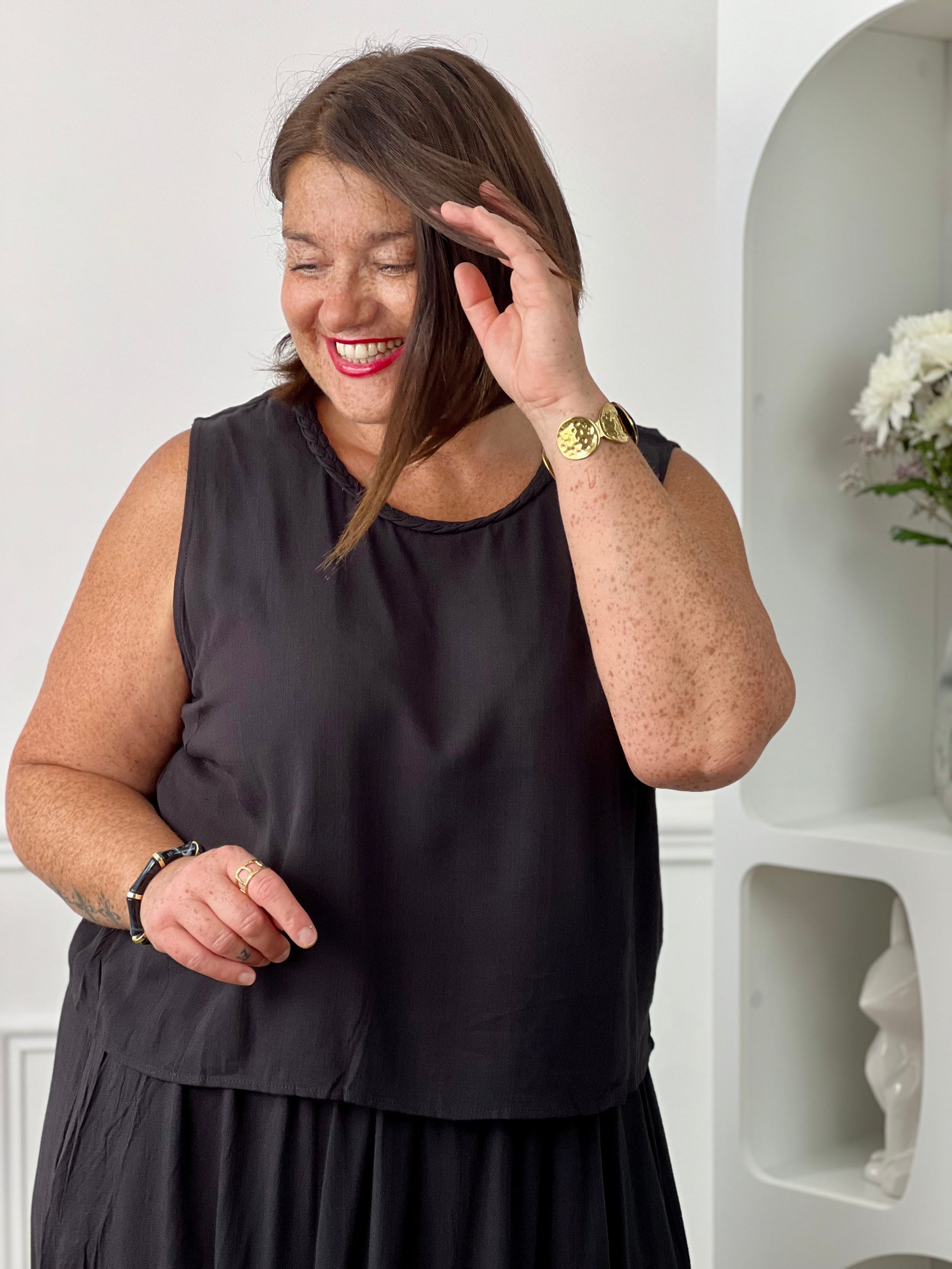 Craquez pour cet ensemble blouse et jupe noire grande taille au style élégant et raffiné. La jupe longue à coupe fluide se distingue par sa fente sur le côté, sa tresse à la taille et son élastique au dos pour un confort optimal. La blouse sans manches, dotée d’un col rond avec détail tressé et d’une ouverture au dos avec bouton, apporte une touche féminine et sophistiquée.