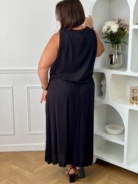 Craquez pour cet ensemble blouse et jupe noire grande taille au style élégant et raffiné. La jupe longue à coupe fluide se distingue par sa fente sur le côté, sa tresse à la taille et son élastique au dos pour un confort optimal. La blouse sans manches, dotée d’un col rond avec détail tressé et d’une ouverture au dos avec bouton, apporte une touche féminine et sophistiquée.