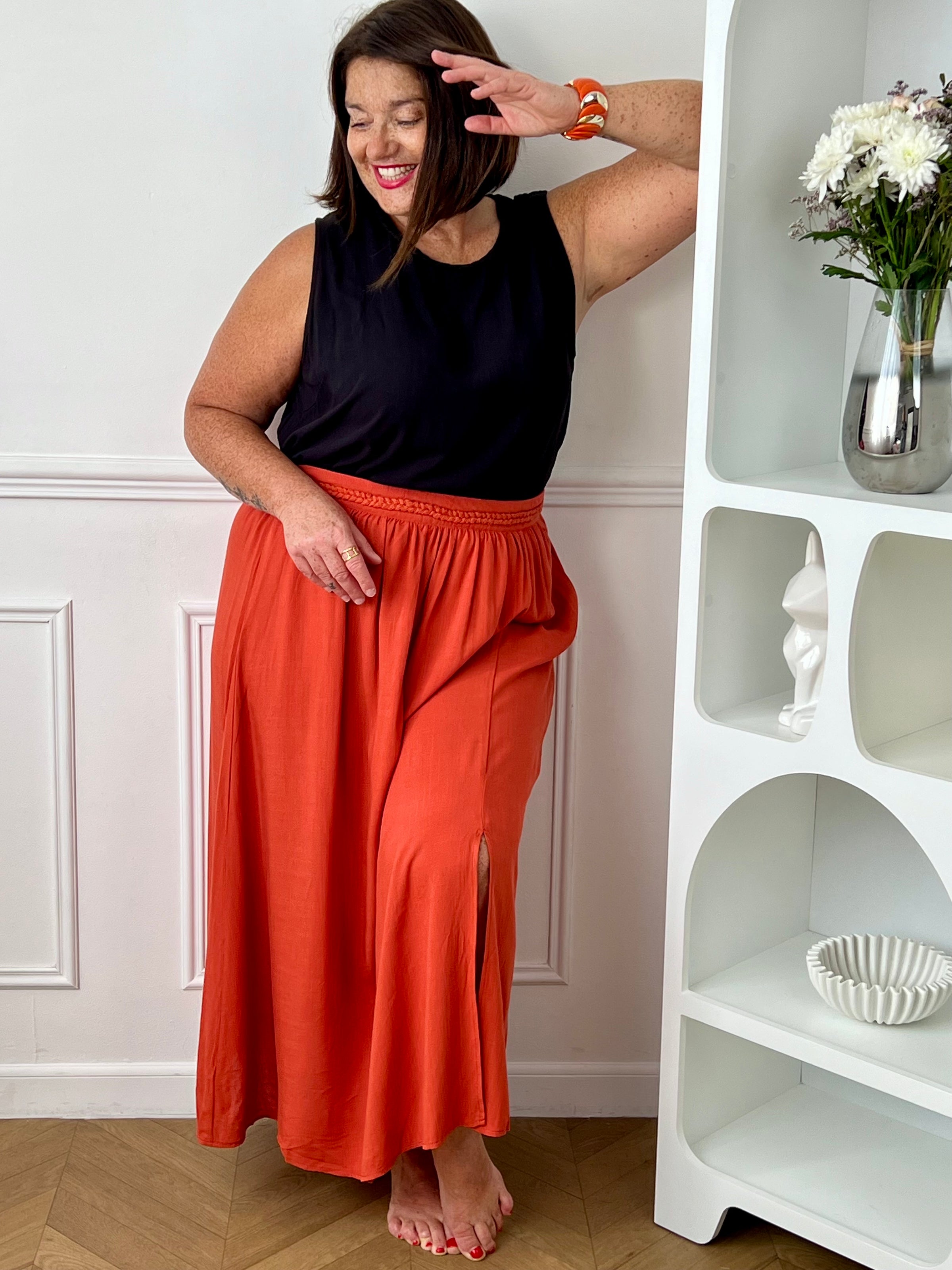 Craquez pour cet ensemble blouse et jupe terracotta grande taille au style élégant et raffiné. La jupe longue à coupe fluide se distingue par sa fente sur le côté, sa tresse à la taille et son élastique au dos pour un confort optimal. La blouse sans manches, dotée d’un col rond avec détail tressé et d’une ouverture au dos avec bouton, apporte une touche féminine et sophistiquée.