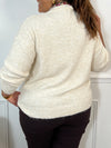Ce pull beige grande taille allie douceur et élégance avec ses manches longues et son col en V orné de délicats motifs floraux. Un coeur brodé vient sublimer le devant, apportant une touche unique et féminine