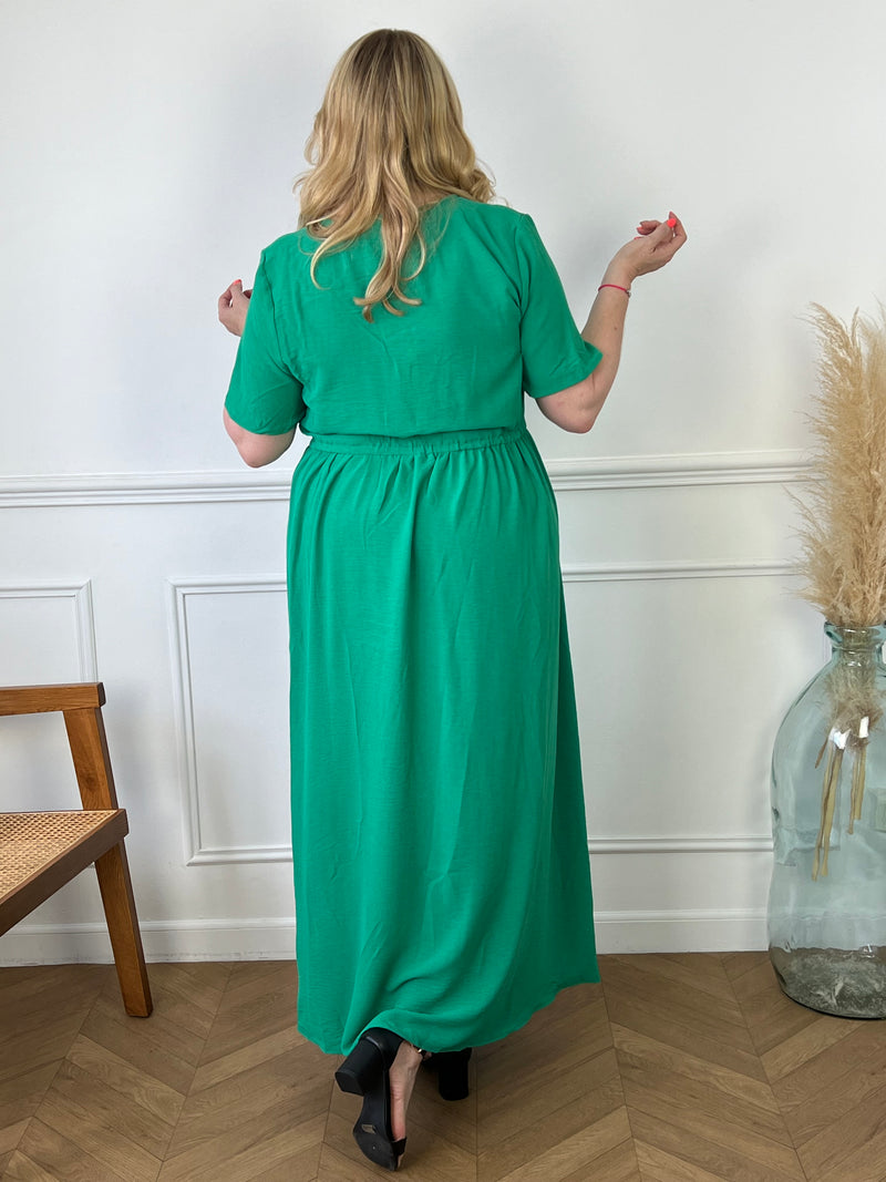 Cette robe longue verte est dotée d'un col en V flatteur, de boutons élégants à l'avant et d'une fente subtile qui ajoute une touche de sensualité. Parfaite pour un look sophistiqué et féminin, elle convient aussi bien pour toutes occasions.