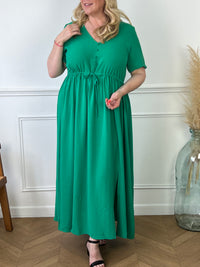 Cette robe longue verte est dotée d'un col en V flatteur, de boutons élégants à l'avant et d'une fente subtile qui ajoute une touche de sensualité. Parfaite pour un look sophistiqué et féminin, elle convient aussi bien pour toutes occasions.