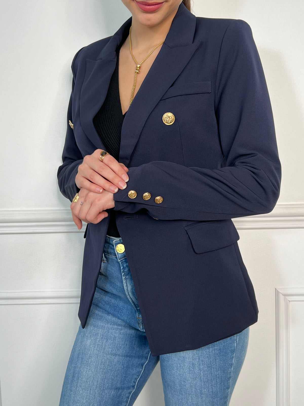 Optez pour une élégance intemporelle avec ce blazer bleu marine orné de boutons dorés. Sa coupe structurée et ses détails sophistiqués en font une pièce idéale pour un look chic et moderne.