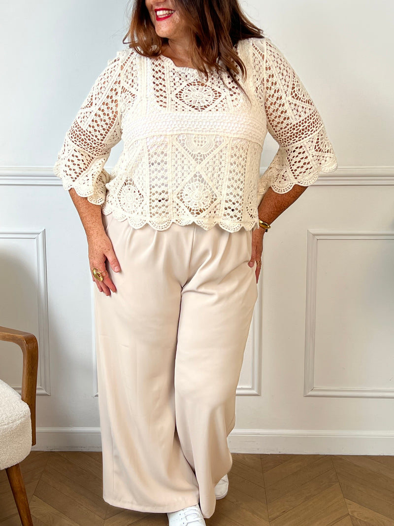 Top en crochet ajouré écru, délicatement travaillé pour un effet à la fois romantique et bohème. Ses manches légèrement évasées aux poignets ajoutent une touche de charme et de fluidité à la silhouette.