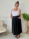 La jupe noire plissée de grande taille incarne une élégance intemporelle. Avec sa coupe longue, elle offre une silhouette flatteuse et tendance. Cette pièce allie style et confort, créant une tenue sophistiquée et moderne pour les femmes de grande taille.