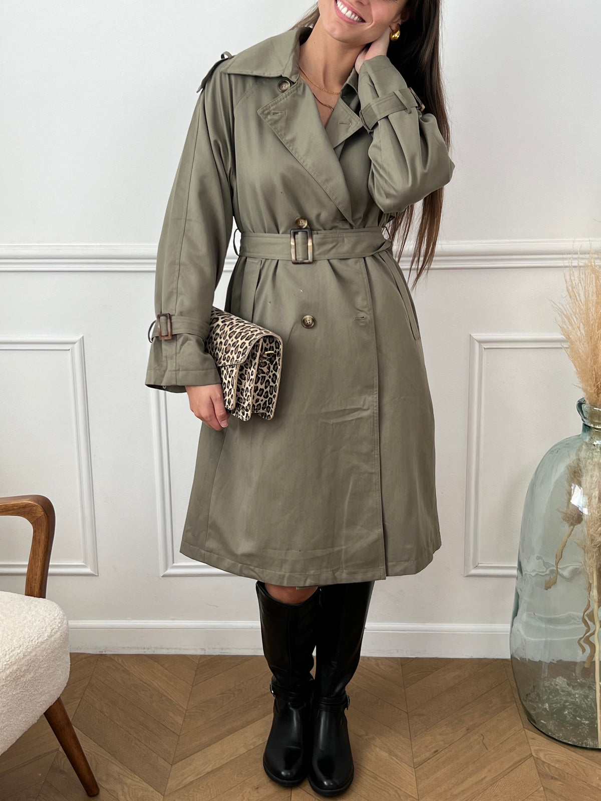 Ajoutez une touche de féminité et de style à votre garde-robe avec notre trench Marlyne en kaki. Doté d'une ceinture amovible à la taille et aux manches pour une silhouette flatteuse. Parfait pour toutes les occasions, ce trench est fendu à l'arrière pour un look à la fois chic et pratique.