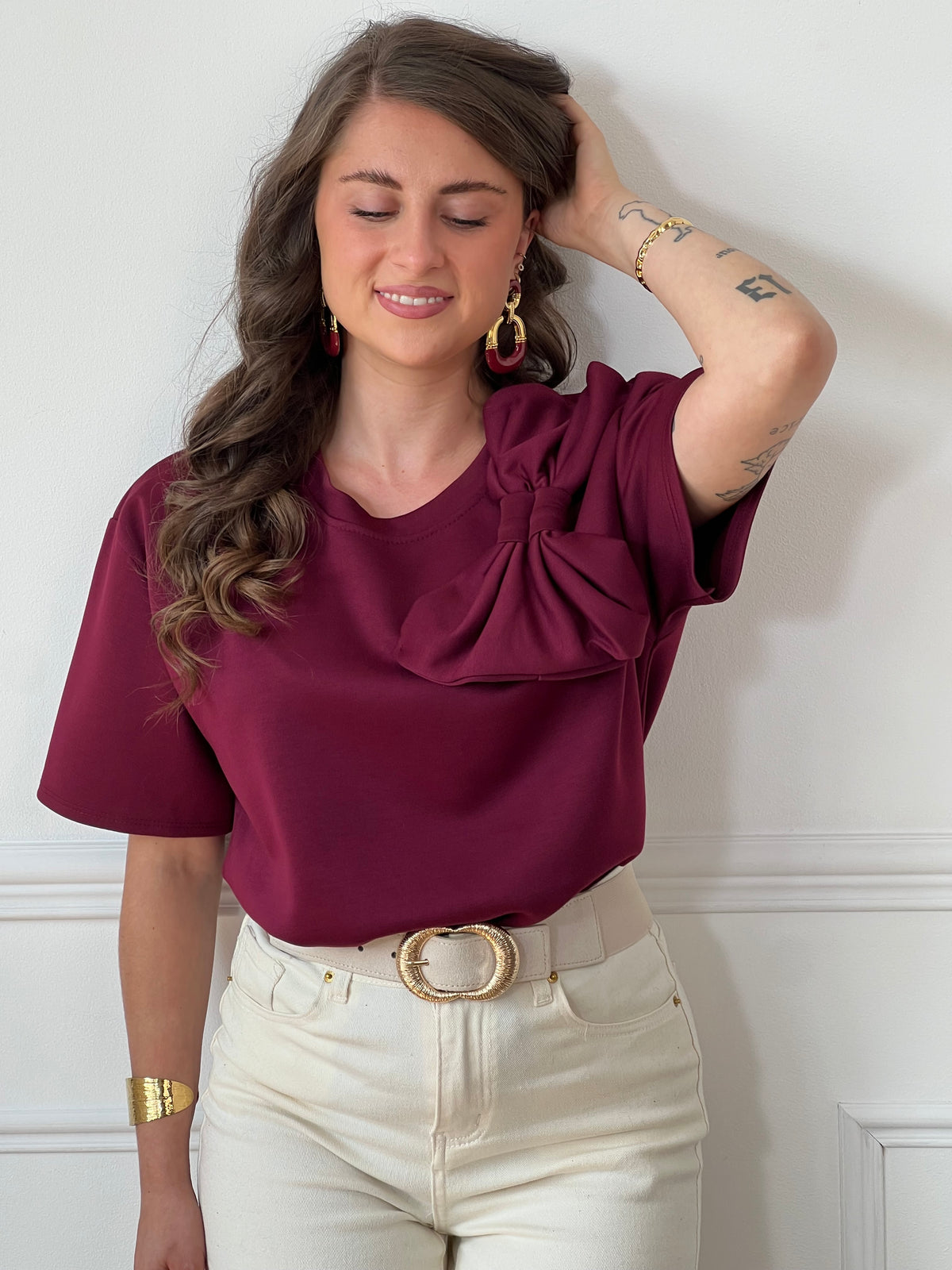 Tee-shirt bordeaux pour femme – Ce tee-shirt à manches courtes est doté d’un col rond et d’un nœud sur le devant pour une touche féminine. Confectionné dans une matière épaisse pour un tombé structuré. Couleur bordeaux, idéale pour la mi-saison.