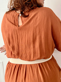 La combinaison Savanah terracotta grande taille allie confort et élégance avec son col cache-cœur, ses manches courtes et son élastique à la taille. Pratique avec ses poches latérales et son ouverture dos à bouton, elle vous met en valeur avec douceur.