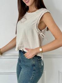 Ce top beige pour femme Tibo, sans manches avec volants, est idéal pour les jours ensoleillés. Les liens de serrage aux épaules ajoutent une touche de charme, tandis que les boutons au dos sur la longueur et le col rond offrent un look élégant et facile à porter.&nbsp;