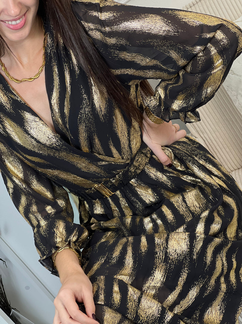 Robe festive Laina, l'allure sophistiquée pour vos soirées. Cette création élégante allie le noir profond et les touches dorées pour une présence rayonnante. Le col cache-cœur flatteuse épouse votre silhouette tandis que la taille élastique offre un confort optimal.