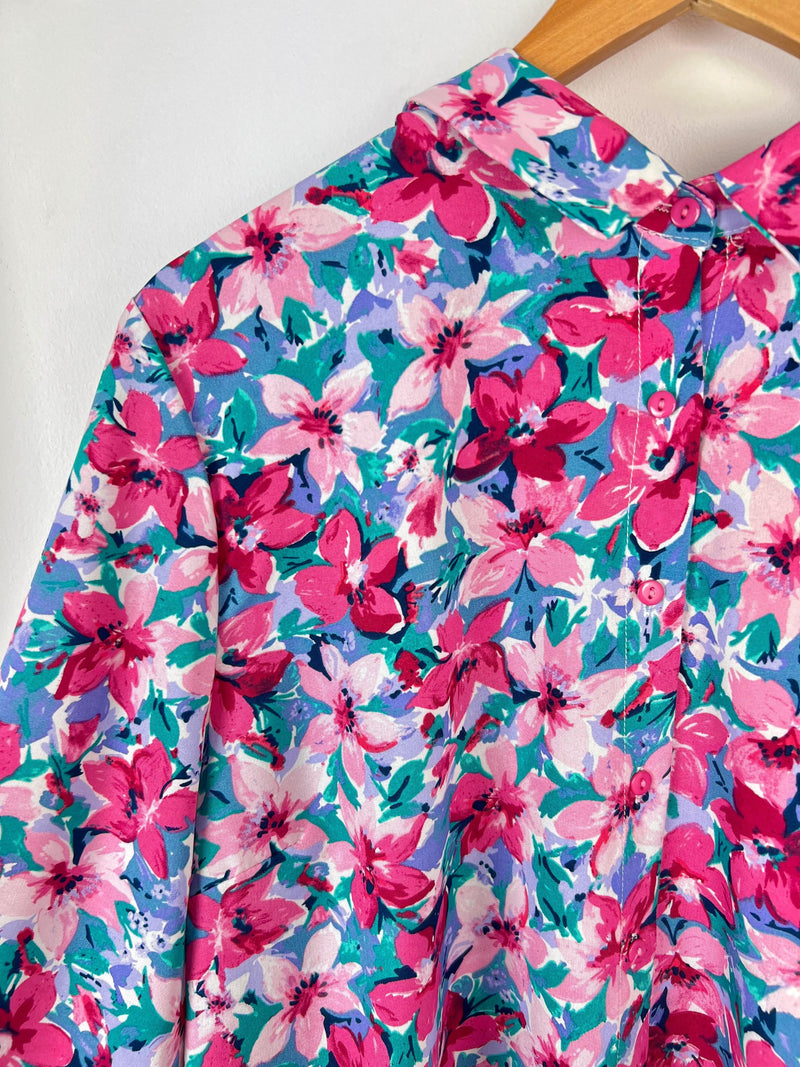 Cette chemise à motifs floraux, aux couleurs lilas, bleu, rose et écru, sera sans aucun doute le reflet de votre personnalité pétillante. Avec son col chemise, elle apportera une touche féminine et élégante à toutes vos tenues. Ajoutez de la couleur et de la joie à votre garde-robe avec la chemise Tyana !