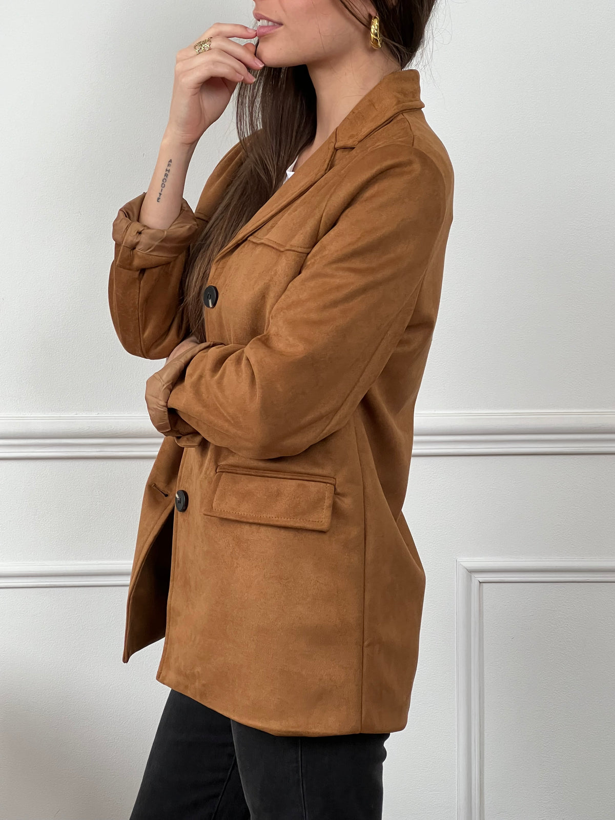 Adoptez une allure élégante et cosy avec cette veste douce en coloris camel. Confectionnée dans une matière effet daim, elle allie style et confort pour vous accompagner en toute occasion. Ses manches longues et ses boutons sur la longueur apportent une touche classique, tandis que ses deux poches factices à l’avant ajoutent une note chic et minimaliste.