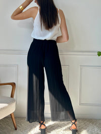 Léger et élégant, ce pantalon plissé noir séduit par sa coupe fluide et sa teinte chaude. Parfait pour une silhouette allongée et un style tout en douceur.