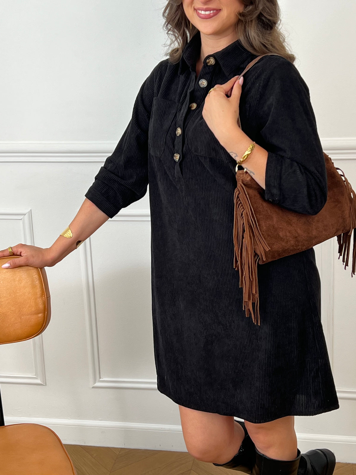 Cette robe courte noire, modèle Cora, allie élégance et confort. Ses manches longues et son col chemise apportent une touche sophistiquée, tandis que les boutons au col et aux manches accentuent son style raffiné.