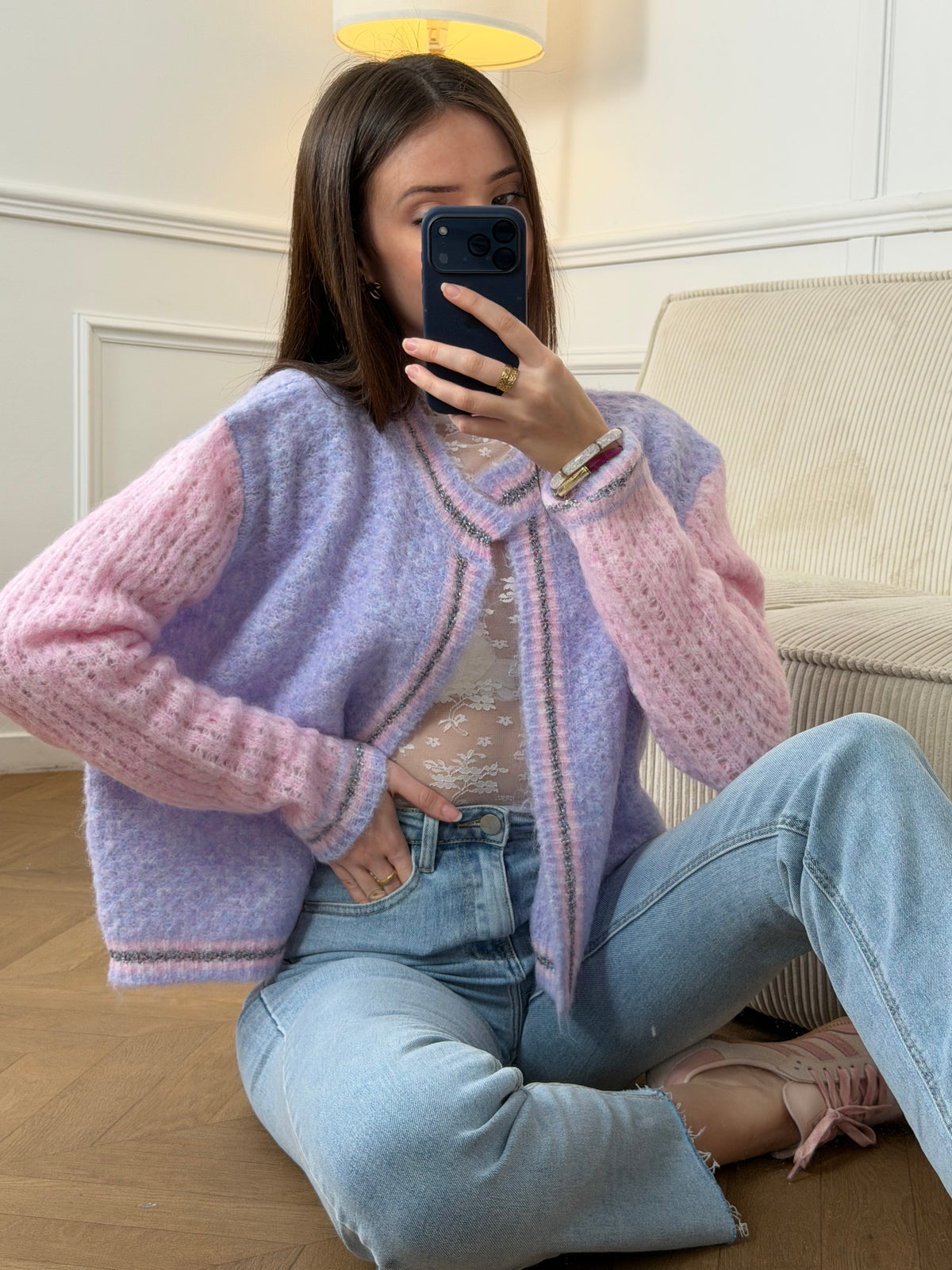 Découvrez le Gilet Nadège, une pièce incontournable alliant style et confort. Ce gilet en laine violet arbore des manches longues roses qui créent un contraste harmonieux et moderne. Son col rond épuré se complète par des bords délicatement ornés de fils colorés brillants, apportant une touche d'éclat à votre silhouette.&nbsp;