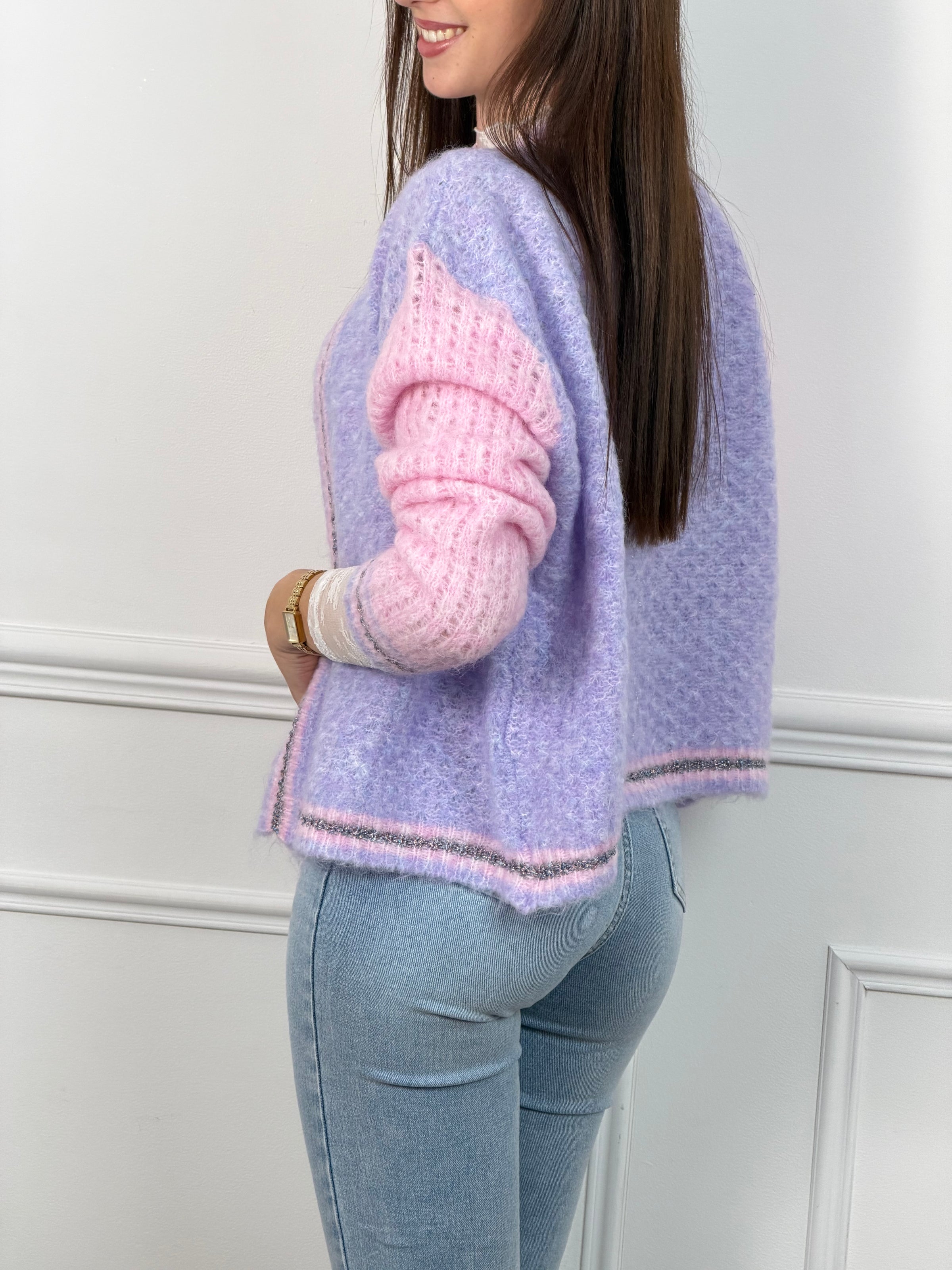 Découvrez le Gilet Nadège, une pièce incontournable alliant style et confort. Ce gilet en laine violet arbore des manches longues roses qui créent un contraste harmonieux et moderne. Son col rond épuré se complète par des bords délicatement ornés de fils colorés brillants, apportant une touche d'éclat à votre silhouette.&nbsp;
