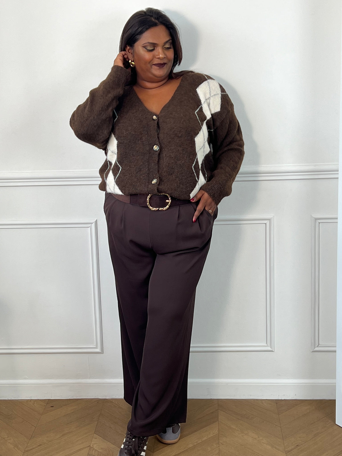 Gilet marron grande taille à losanges blancs et gris, porté rentré à l’avant dans un pantalon ceinturé – Isadora | Loïcia
