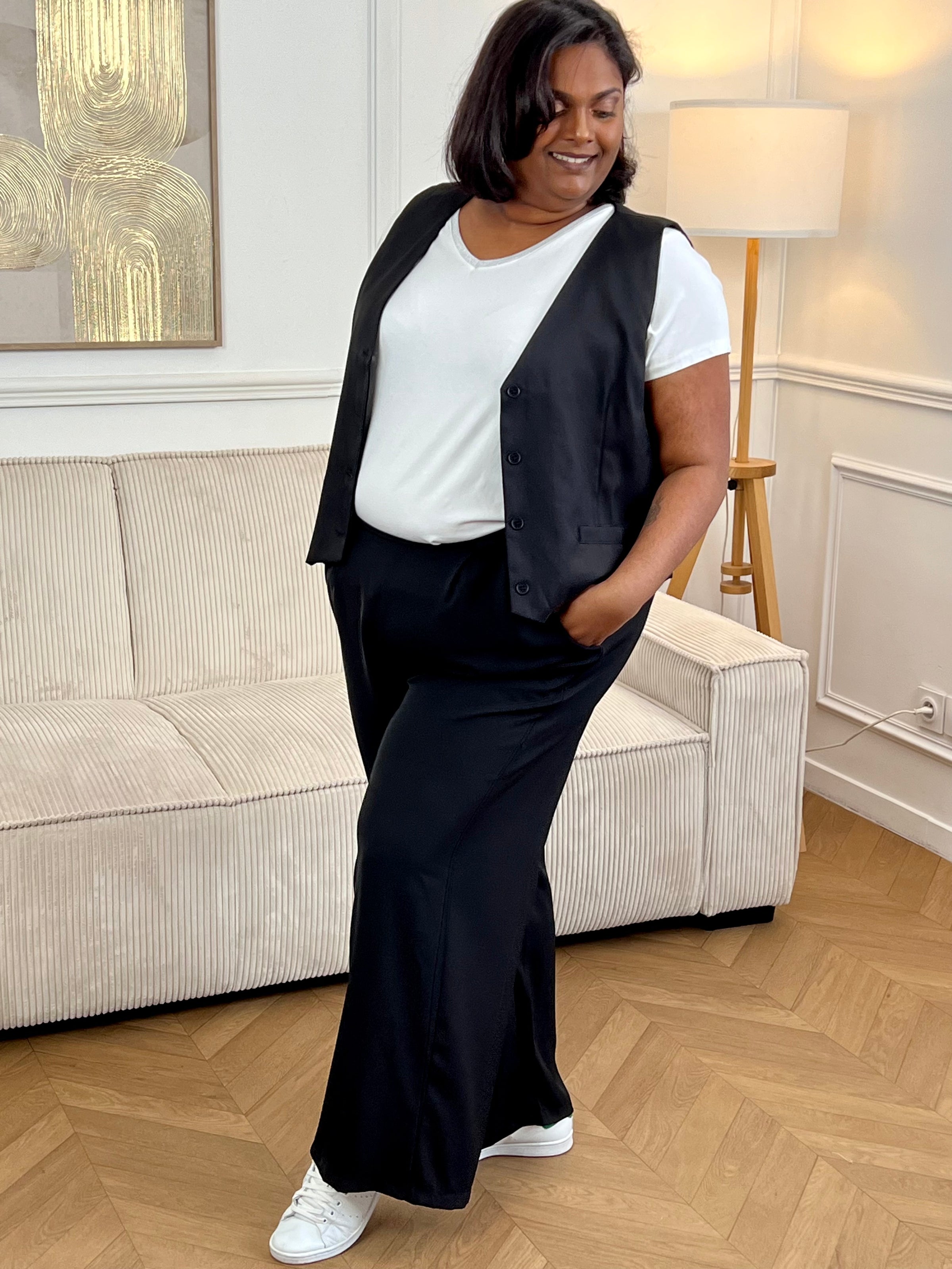 Adoptez ce gilet court de tailleur grande taille femme, élégant et structuré. Sans manches, il se distingue par son col V flatteur et ses boutons sur toute la longueur. Ses deux poches factices à l’avant apportent une touche chic supplémentaire. En noir, il complète parfaitement un look habillé ou moderne.