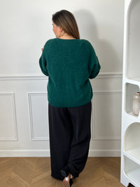 Cardigan vert sapin col V grande taille - vue de dos avec pantalon large noir fluide mettant en valeur la coupe oversize et le tombé du gilet