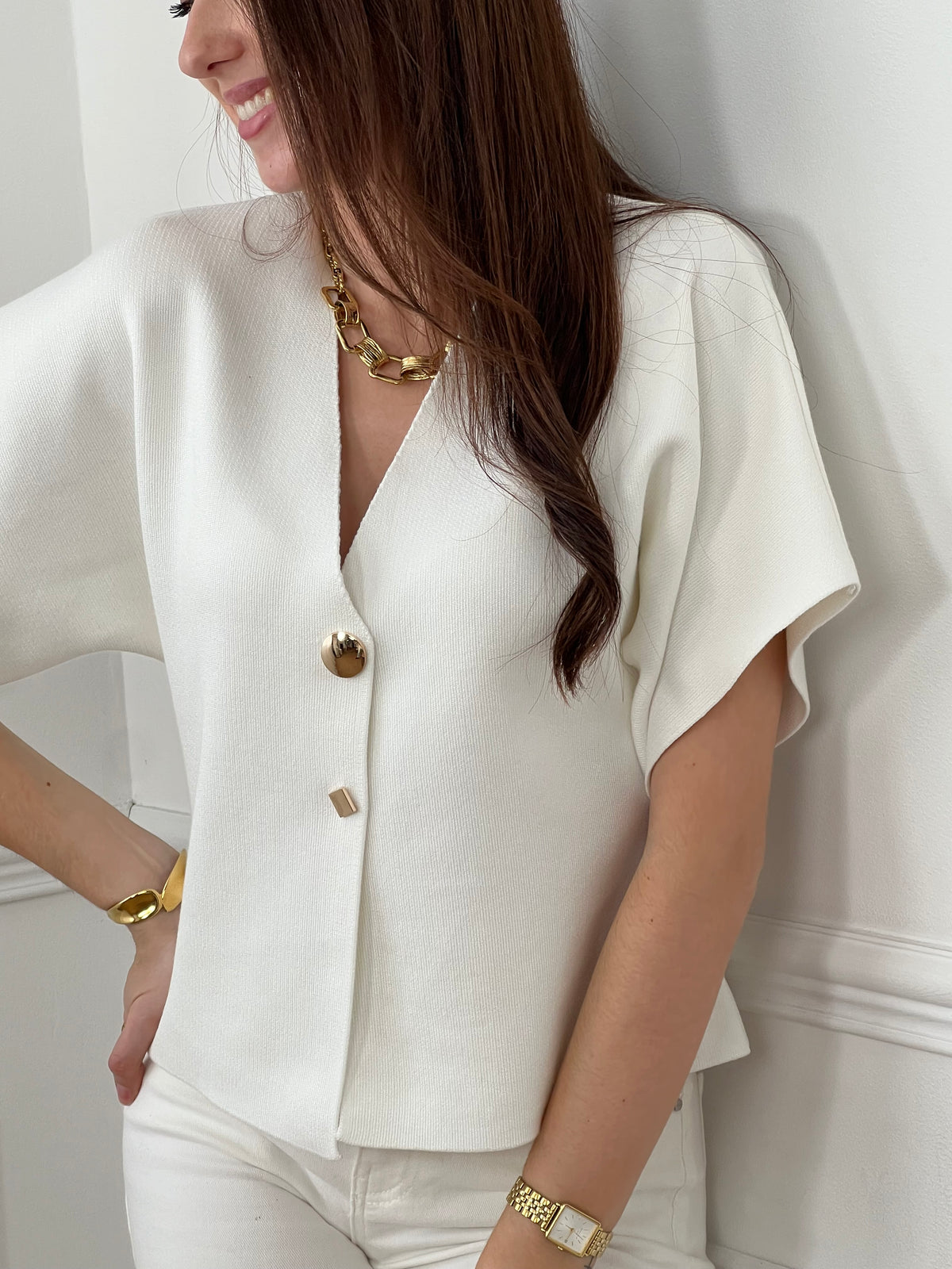 Craquez pour ce gilet écru femme, lumineux et élégant. Doté d’un col V et de manches courtes, il se distingue par ses deux boutons dorés aux formes rondes et carrées sur la longueur. Sa couleur écru sublimée par des détails dorés apporte une touche chic et originale à votre tenue.