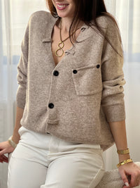 Le gilet Anatole en taupe est l'allié parfait de votre dressing. Avec son col V flatteuse, ses manches longues et ses boutons noirs alignés sur toute la longueur, il combine élégance et style. Les petits passants décoratifs finalisent ce basique intemporel à porter sans modération.