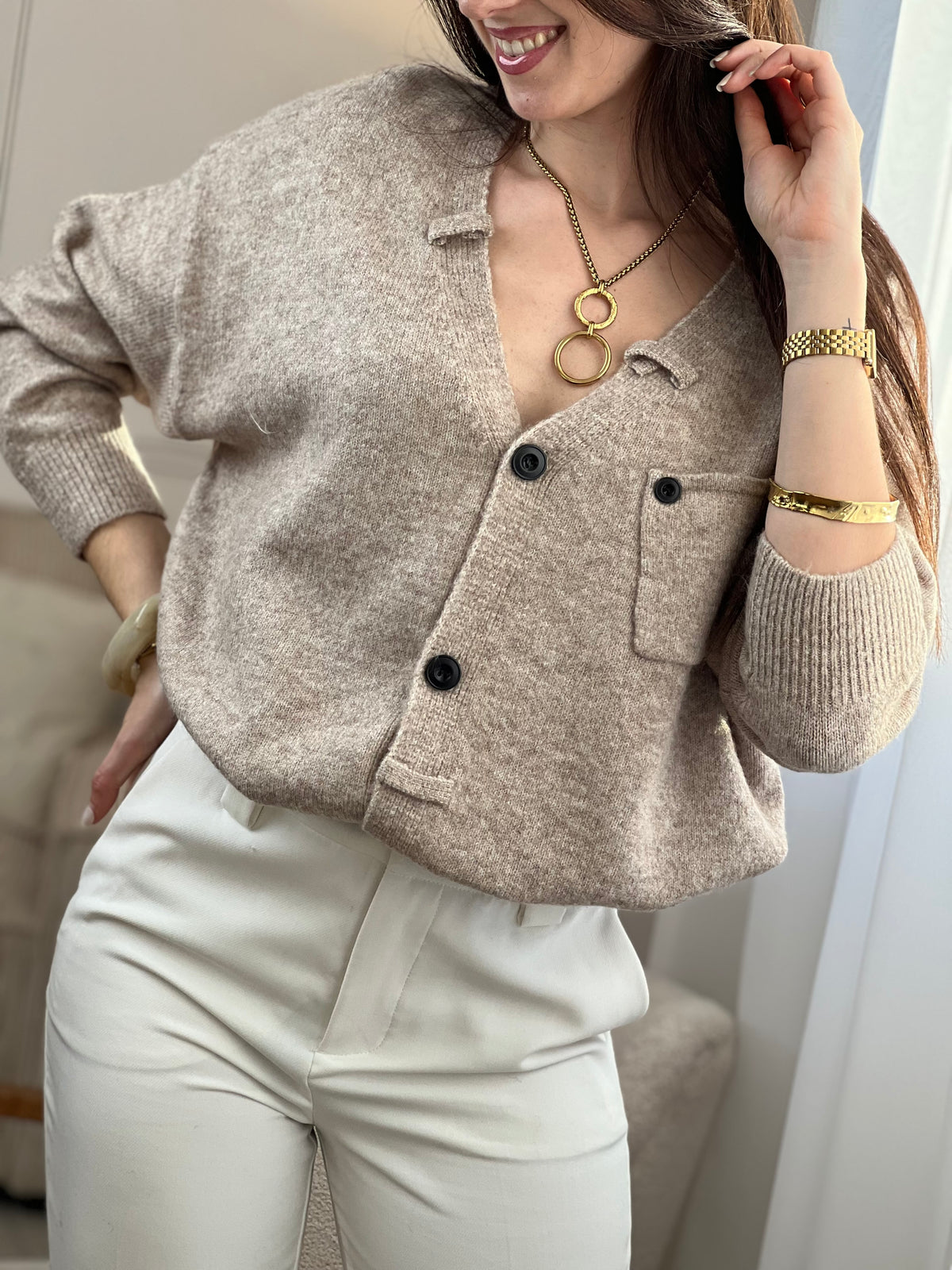 Le gilet Anatole en taupe est l'allié parfait de votre dressing. Avec son col V flatteuse, ses manches longues et ses boutons noirs alignés sur toute la longueur, il combine élégance et style. Les petits passants décoratifs finalisent ce basique intemporel à porter sans modération.