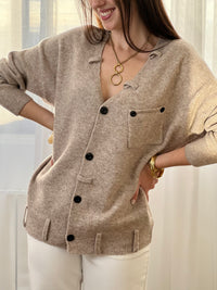 Le gilet Anatole en taupe est l'allié parfait de votre dressing. Avec son col V flatteuse, ses manches longues et ses boutons noirs alignés sur toute la longueur, il combine élégance et style. Les petits passants décoratifs finalisent ce basique intemporel à porter sans modération.