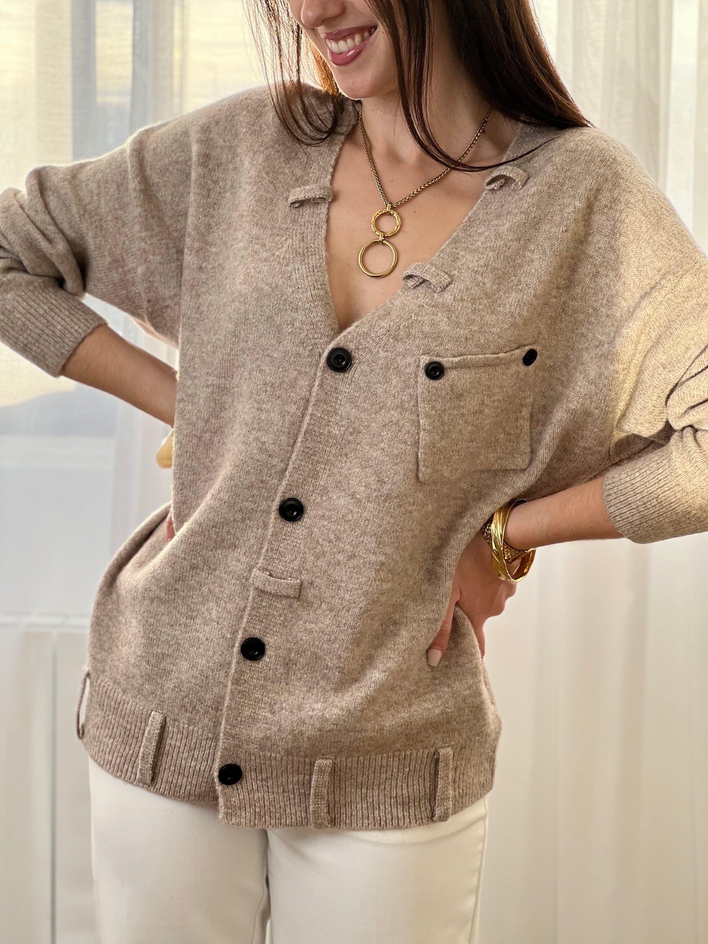 Le gilet Anatole en taupe est l'allié parfait de votre dressing. Avec son col V flatteuse, ses manches longues et ses boutons noirs alignés sur toute la longueur, il combine élégance et style. Les petits passants décoratifs finalisent ce basique intemporel à porter sans modération.