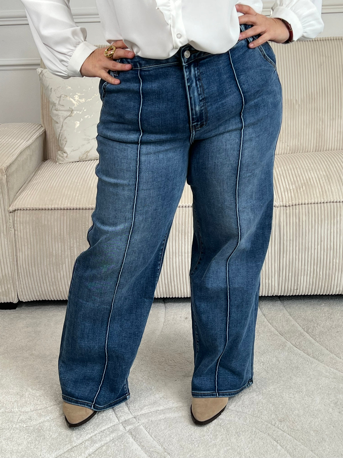 Jean bleu grande taille avec coupe wide leg flatteuse. La couture centrale verticale affine la silhouette tandis que les passants pour ceinture offrent plus de flexibilité. Fermeture éclair et bouton sécurisés, quatre poches pratiques. Un basique intemporel et confortable pour votre garde-robe.