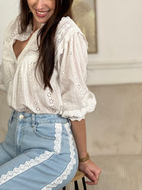 Jean bleu femme coupe large et intemporelle. Fermeture à zip et bouton pour un maintien sûr. Quatre poches pratiques pour ranger vos essentiels. Détail broderie élégant qui court sur toute la longueur, apportant une touche de caractère à votre garde-robe. Disponible en bleu classique et écru subtil.