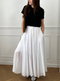 Jupe longue blanche ample avec taille élastique, légère et fluide pour une silhouette à la fois confortable et féminine.