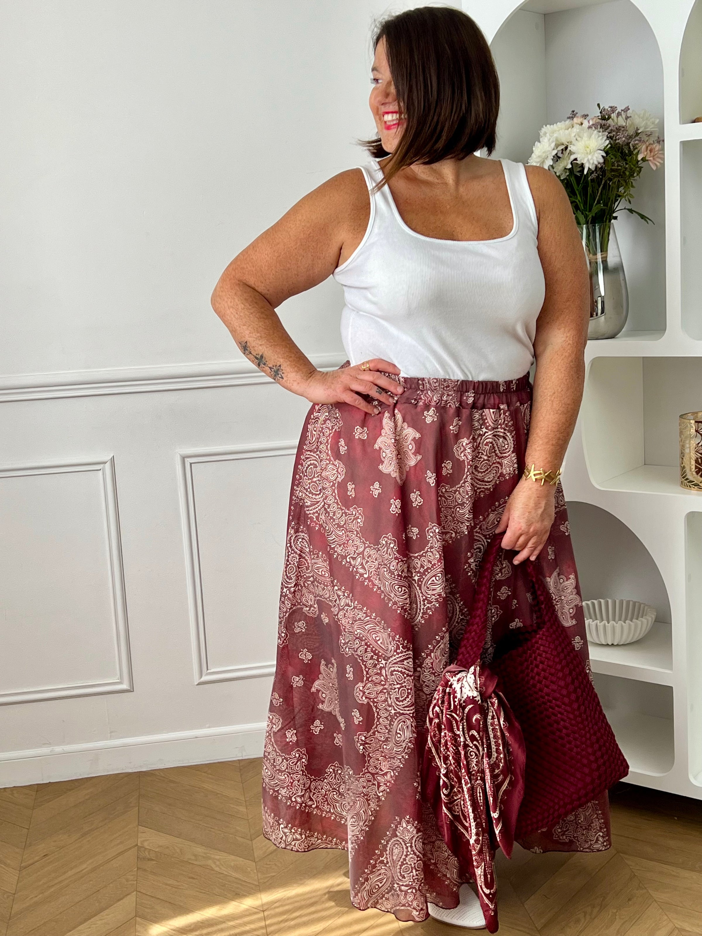 Apportez une touche d’élégance à votre dressing avec cette jupe longue bordeaux grande taille aux motifs écrus raffinés. Sa coupe évasée offre un tombé fluide et féminin, tandis que l’élastique à la taille assure un confort optimal au quotidien. Doublée jusqu’à mi-longueur pour plus d’aisance, cette jupe chic et légère est idéale pour composer des looks tendance et confortables.