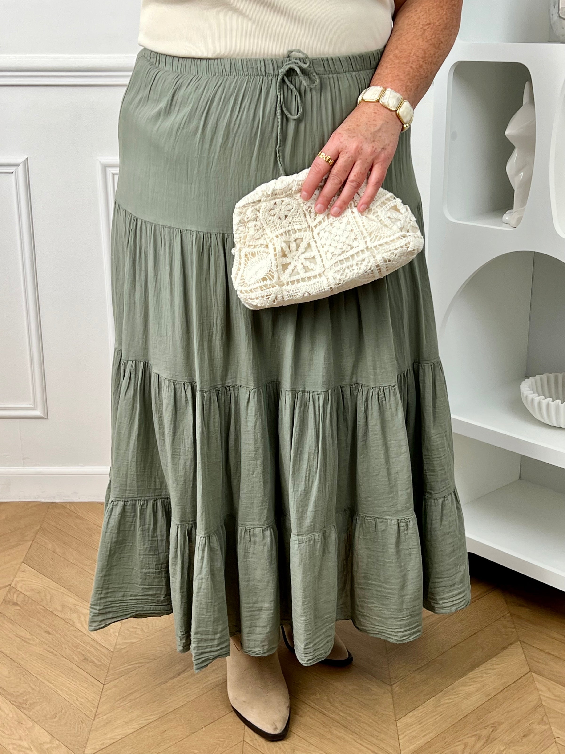 Jupe longue grande taille femme, ample et légère, idéale pour un look confortable et féminin. Dotée d’une taille élastique avec liens factices, elle s’adapte parfaitement à la silhouette. Sa doublure jusqu’à mi-longueur assure confort et opacité au quotidien. Confectionnée en 100% coton, cette jupe kaki est parfaite pour une tenue chic et décontractée en toute saison.
