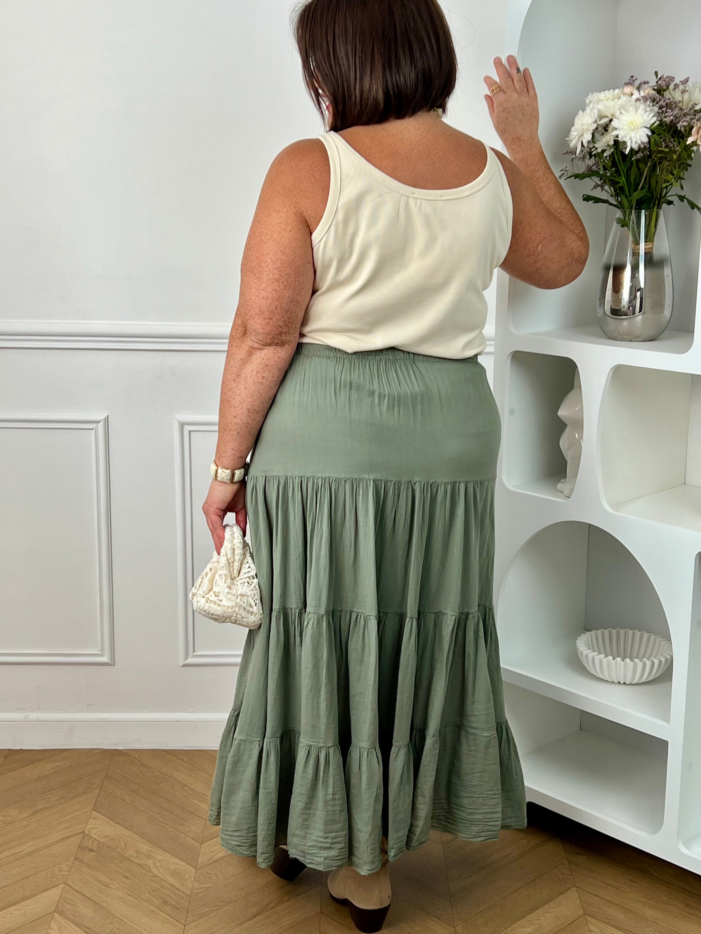 Jupe longue grande taille femme, ample et légère, idéale pour un look confortable et féminin. Dotée d’une taille élastique avec liens factices, elle s’adapte parfaitement à la silhouette. Sa doublure jusqu’à mi-longueur assure confort et opacité au quotidien. Confectionnée en 100% coton, cette jupe kaki est parfaite pour une tenue chic et décontractée en toute saison.