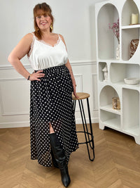 Adoptez cette jupe longue à pois grande taille, à la fois chic et confortable. Sa taille élastiquée s’ajuste facilement à votre silhouette. Ses motifs noir et écru apportent une touche intemporelle, tandis que sa fente sur le côté droit et sa doublure jusqu’aux genoux offrent fluidité et aisance au quotidien.