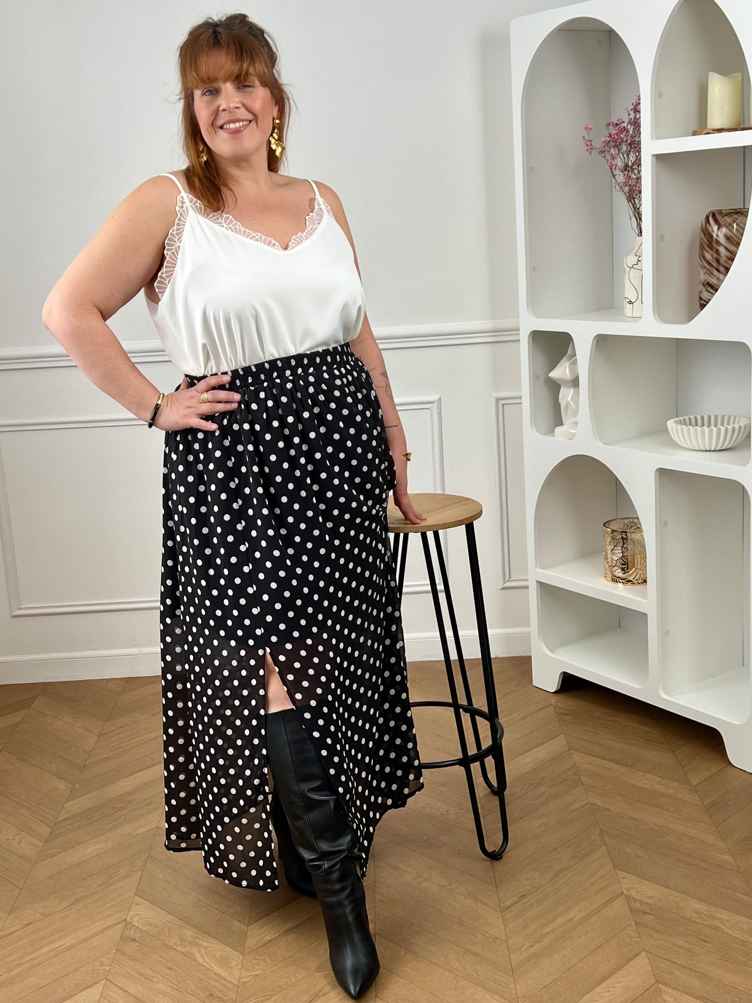 Adoptez cette jupe longue à pois grande taille, à la fois chic et confortable. Sa taille élastiquée s’ajuste facilement à votre silhouette. Ses motifs noir et écru apportent une touche intemporelle, tandis que sa fente sur le côté droit et sa doublure jusqu’aux genoux offrent fluidité et aisance au quotidien.