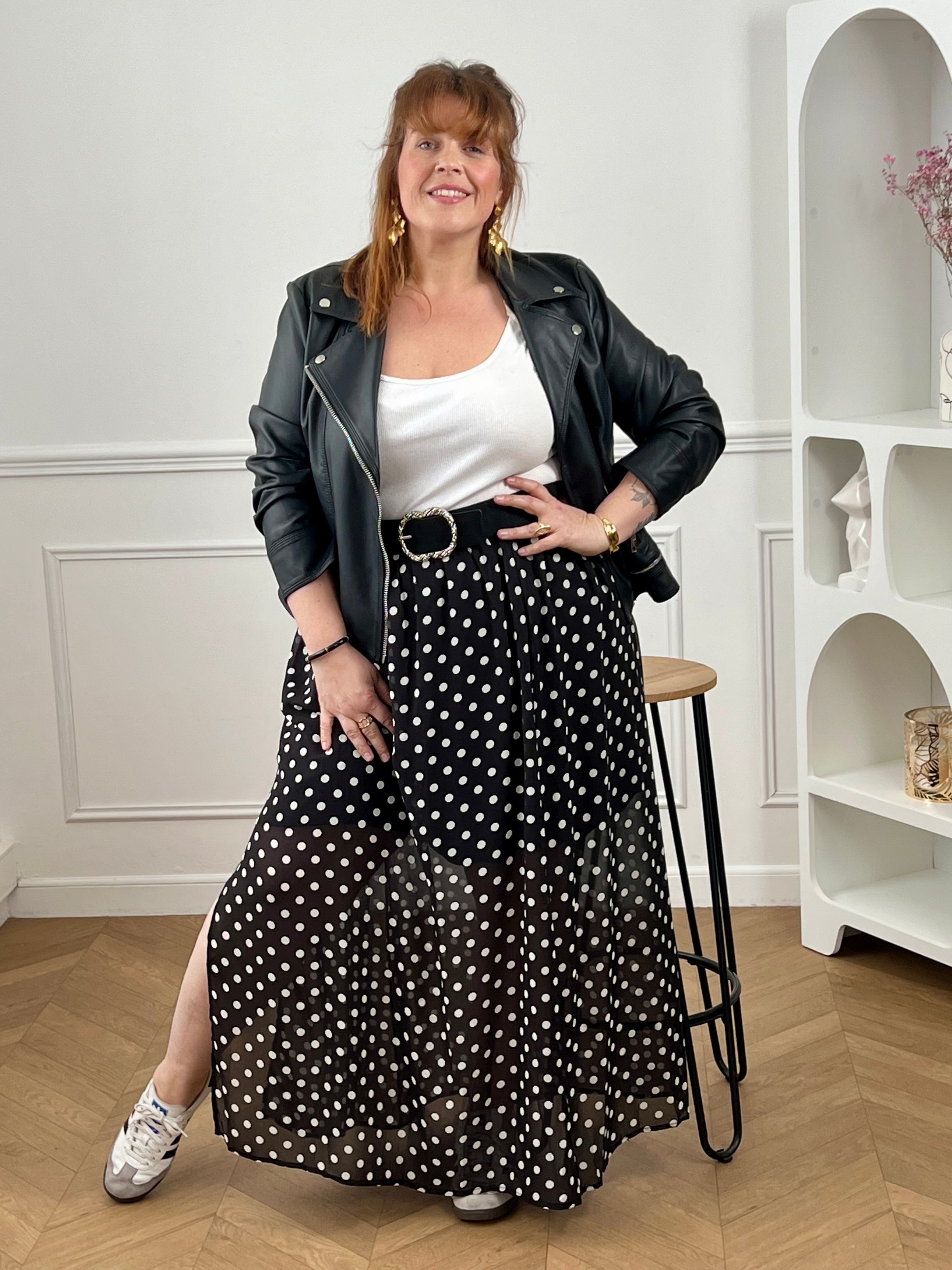 Adoptez cette jupe longue à pois grande taille, à la fois chic et confortable. Sa taille élastiquée s’ajuste facilement à votre silhouette. Ses motifs noir et écru apportent une touche intemporelle, tandis que sa fente sur le côté droit et sa doublure jusqu’aux genoux offrent fluidité et aisance au quotidien.