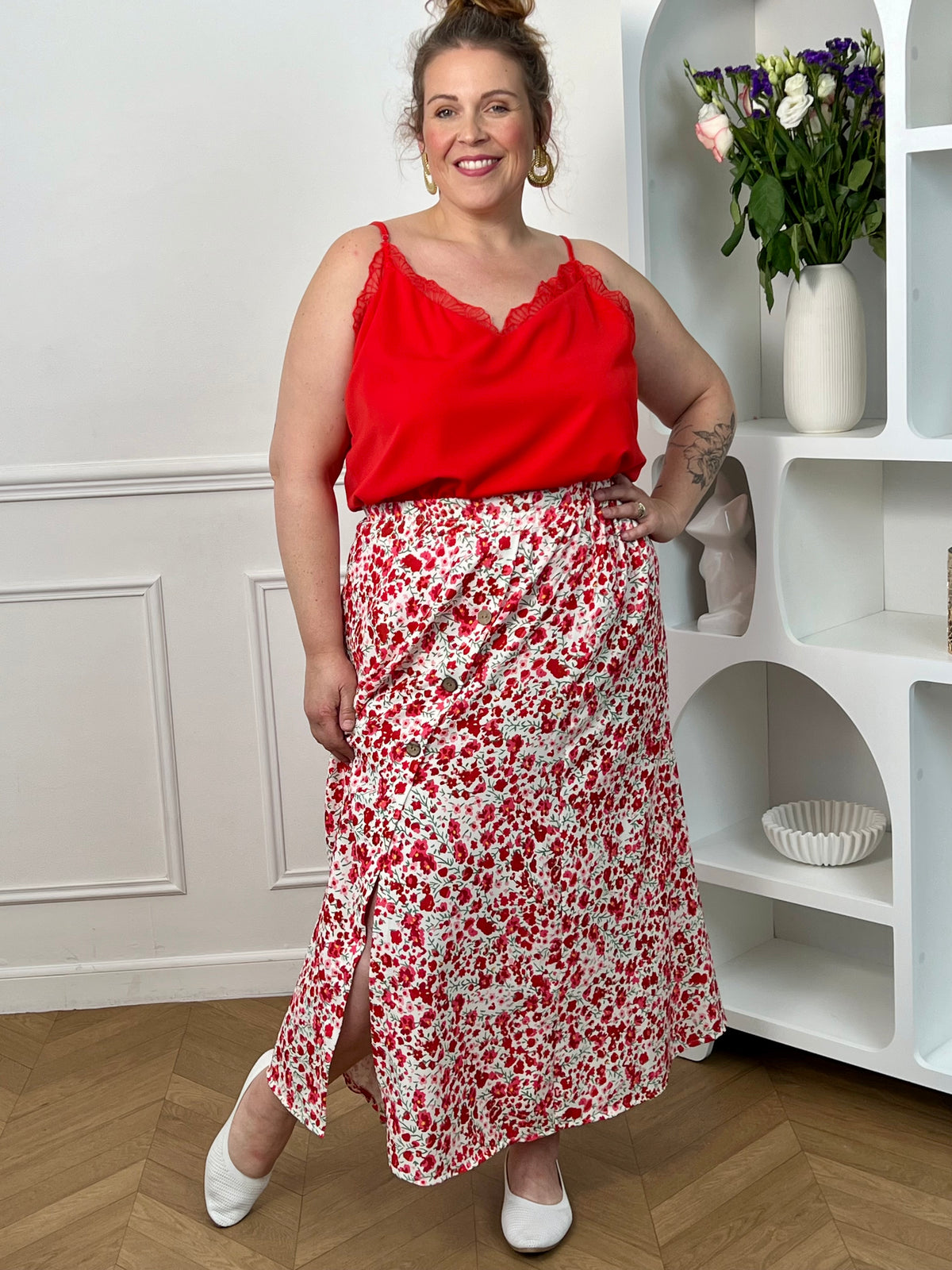 Jupe fleurie écru, rose et rouge à la coupe fluide et féminine. Sa taille élastique assure un confort parfait, tandis que la fente à l’avant apporte une touche légère et élégante.