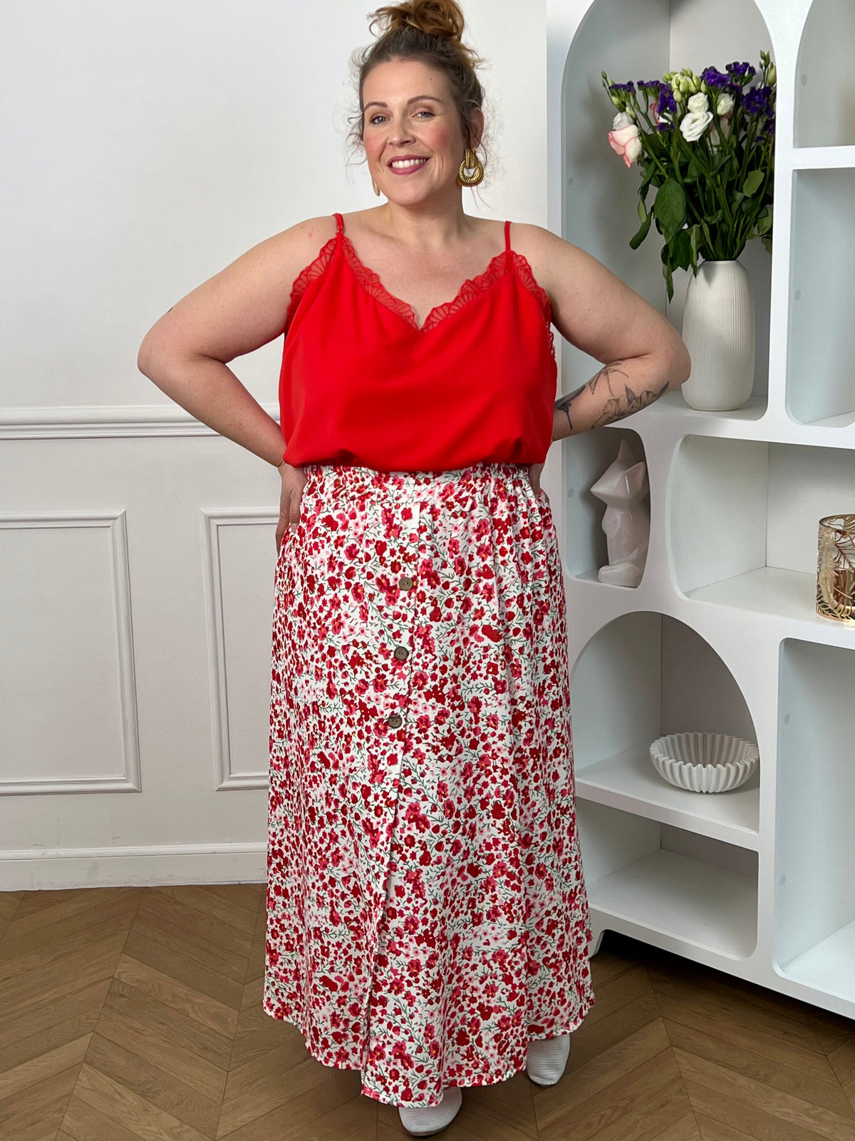 Jupe fleurie écru, rose et rouge à la coupe fluide et féminine. Sa taille élastique assure un confort parfait, tandis que la fente à l’avant apporte une touche légère et élégante.