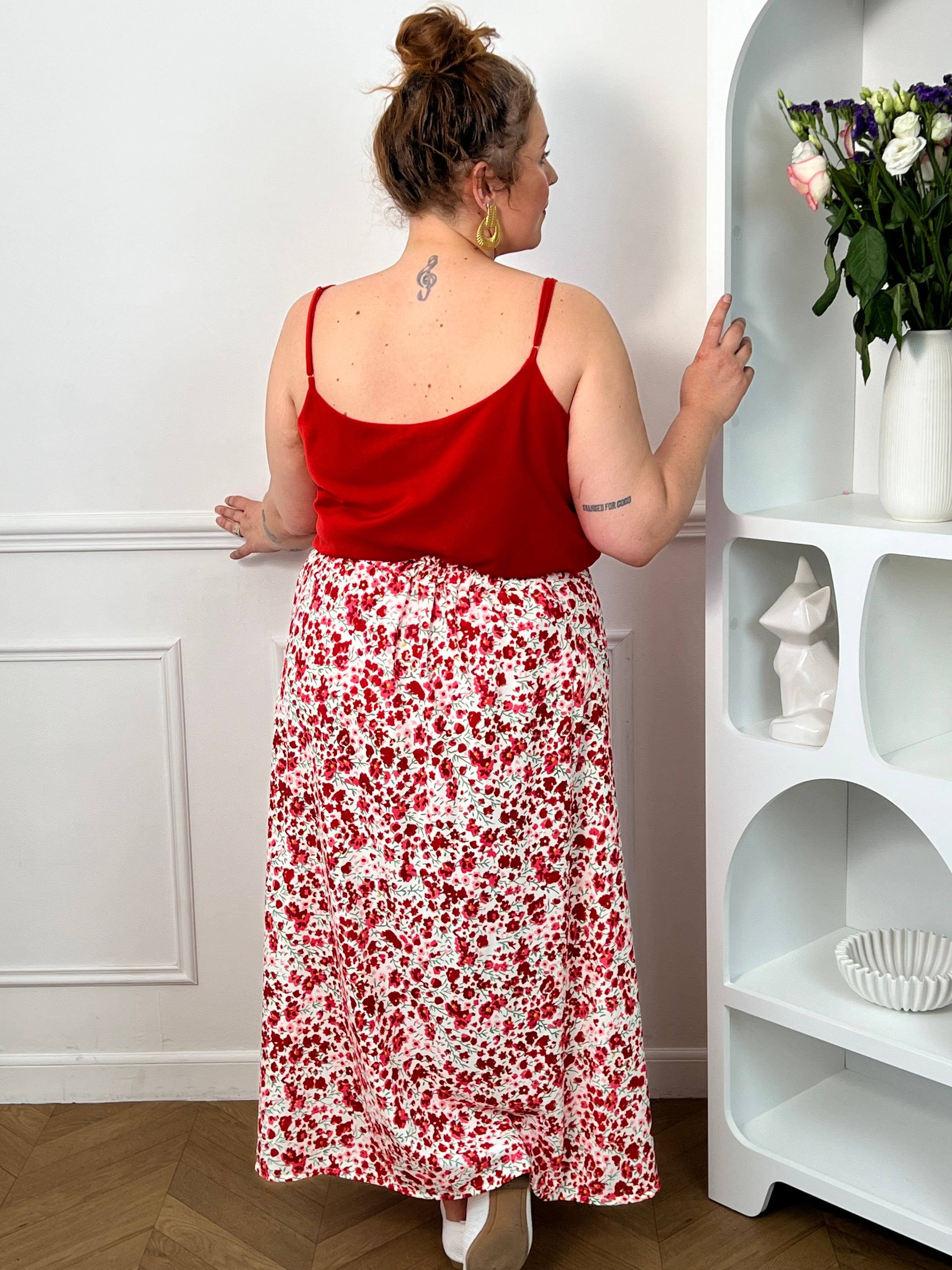 Jupe fleurie écru, rose et rouge à la coupe fluide et féminine. Sa taille élastique assure un confort parfait, tandis que la fente à l’avant apporte une touche légère et élégante.