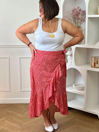 Jupe longue rouge grande taille femme, au style portefeuille, idéale pour une allure féminine et élégante. Dotée d’une taille élastique, elle offre un confort optimal au quotidien. Son volant apporte du mouvement, tandis que son motif floral rehaussé de fil lurex doré ajoute une touche lumineuse et raffinée. Parfaite pour sublimer vos tenues avec style.