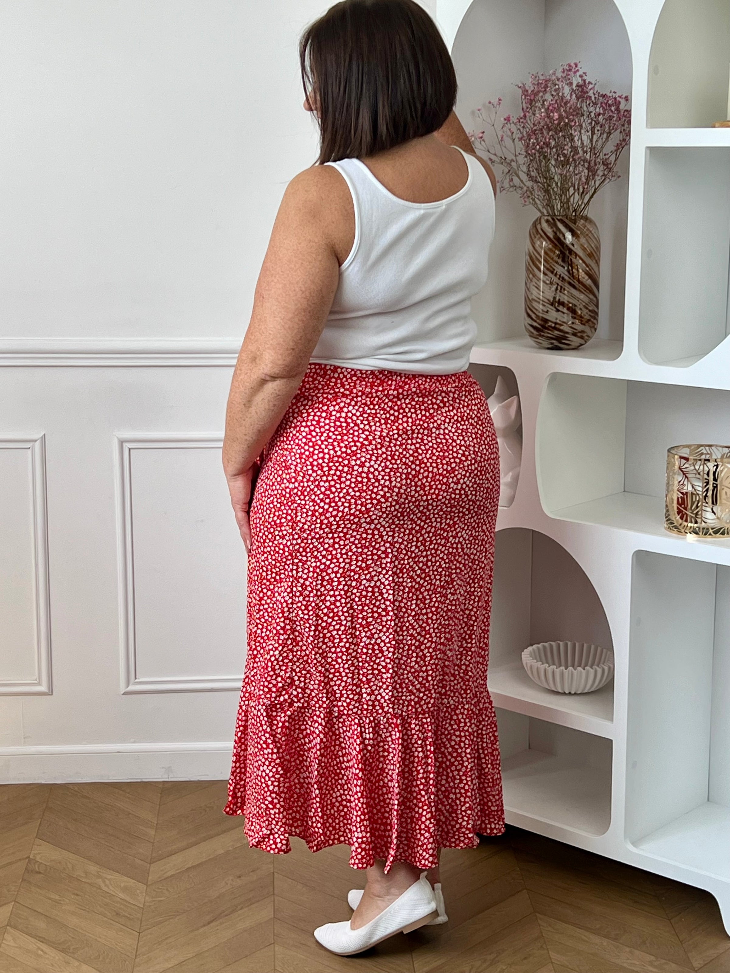 Jupe longue rouge grande taille femme, au style portefeuille, idéale pour une allure féminine et élégante. Dotée d’une taille élastique, elle offre un confort optimal au quotidien. Son volant apporte du mouvement, tandis que son motif floral rehaussé de fil lurex doré ajoute une touche lumineuse et raffinée. Parfaite pour sublimer vos tenues avec style.
