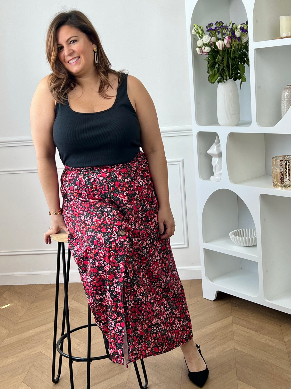 Jupe fleurie noire, rose et rouge à la coupe fluide et féminine. Sa taille élastique assure un confort parfait, tandis que la fente à l’avant apporte une touche légère et élégante.