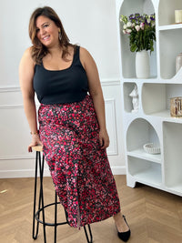 Jupe fleurie noire, rose et rouge à la coupe fluide et féminine. Sa taille élastique assure un confort parfait, tandis que la fente à l’avant apporte une touche légère et élégante.