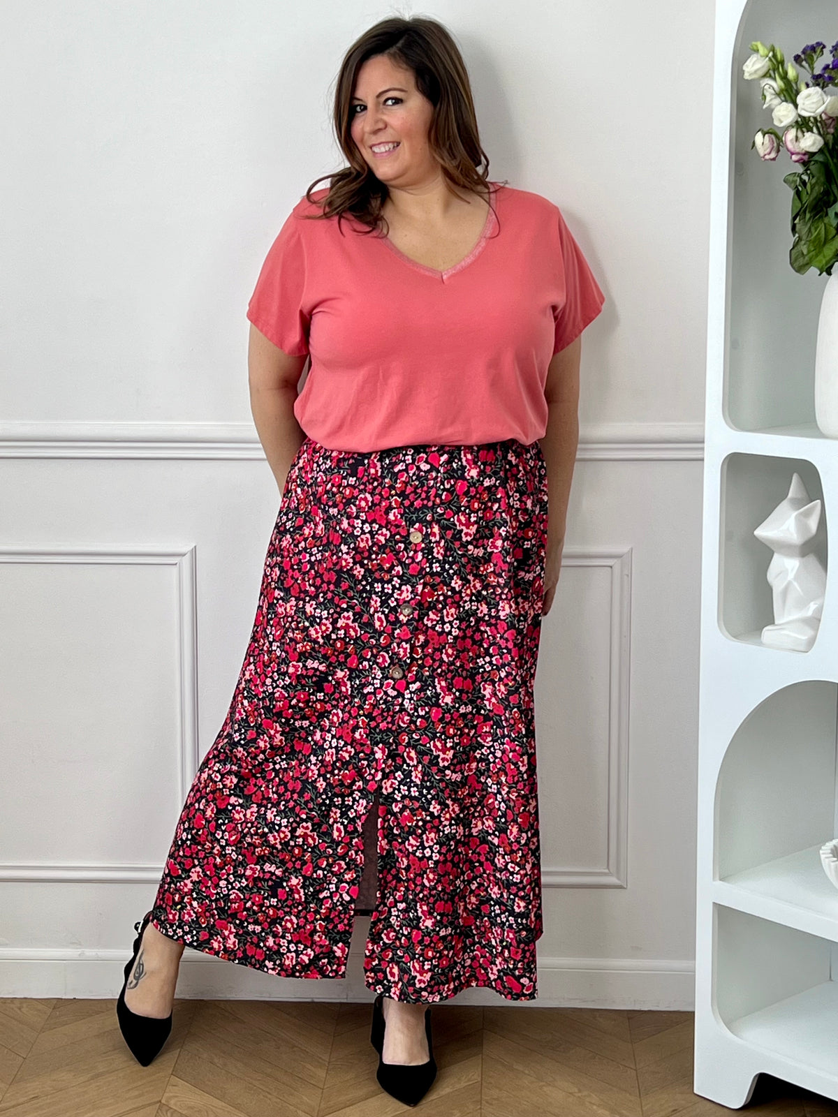 Jupe fleurie noire, rose et rouge à la coupe fluide et féminine. Sa taille élastique assure un confort parfait, tandis que la fente à l’avant apporte une touche légère et élégante.