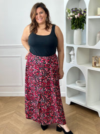 Jupe fleurie noire, rose et rouge à la coupe fluide et féminine. Sa taille élastique assure un confort parfait, tandis que la fente à l’avant apporte une touche légère et élégante.