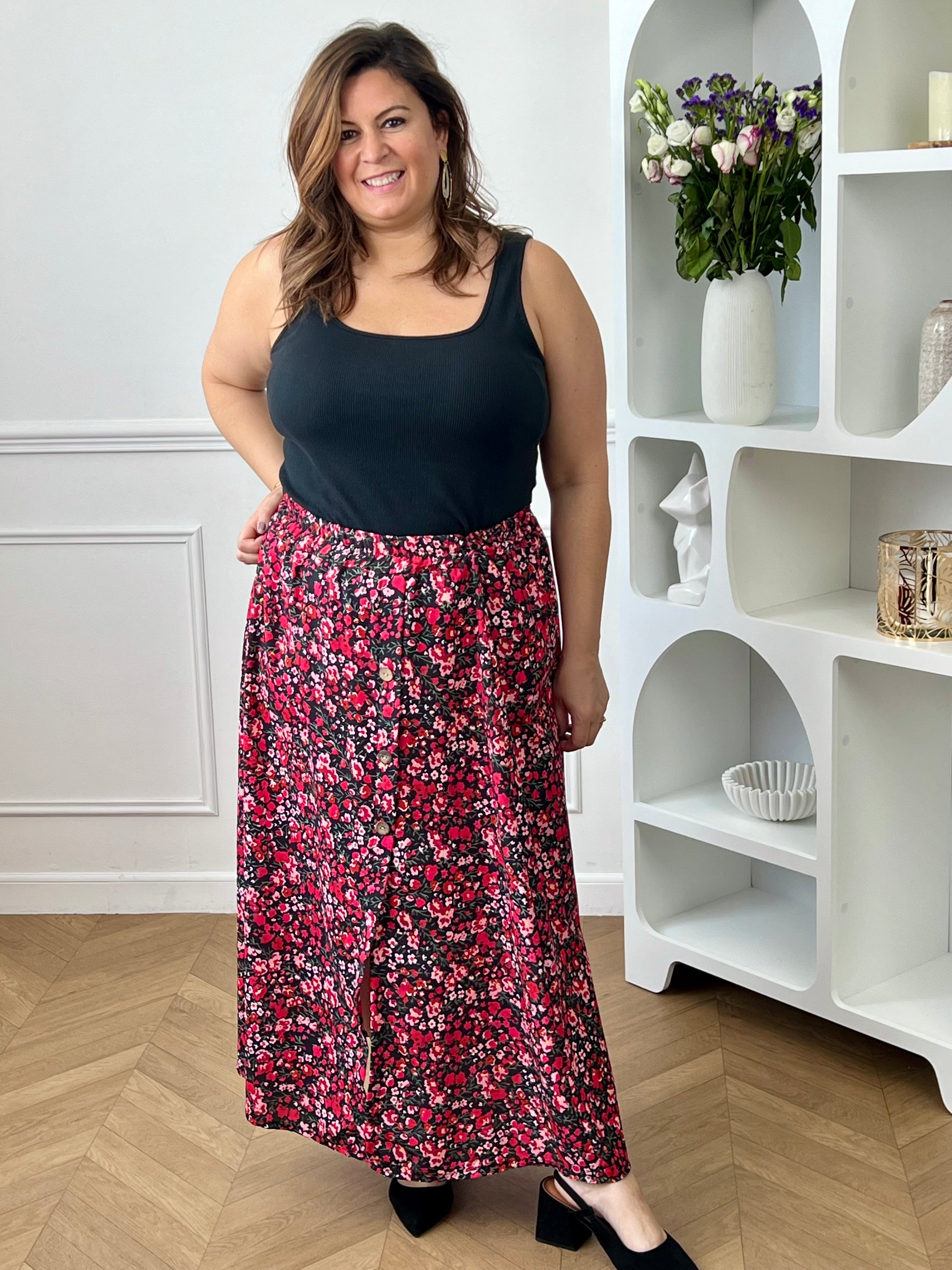 Jupe fleurie noire, rose et rouge à la coupe fluide et féminine. Sa taille élastique assure un confort parfait, tandis que la fente à l’avant apporte une touche légère et élégante.