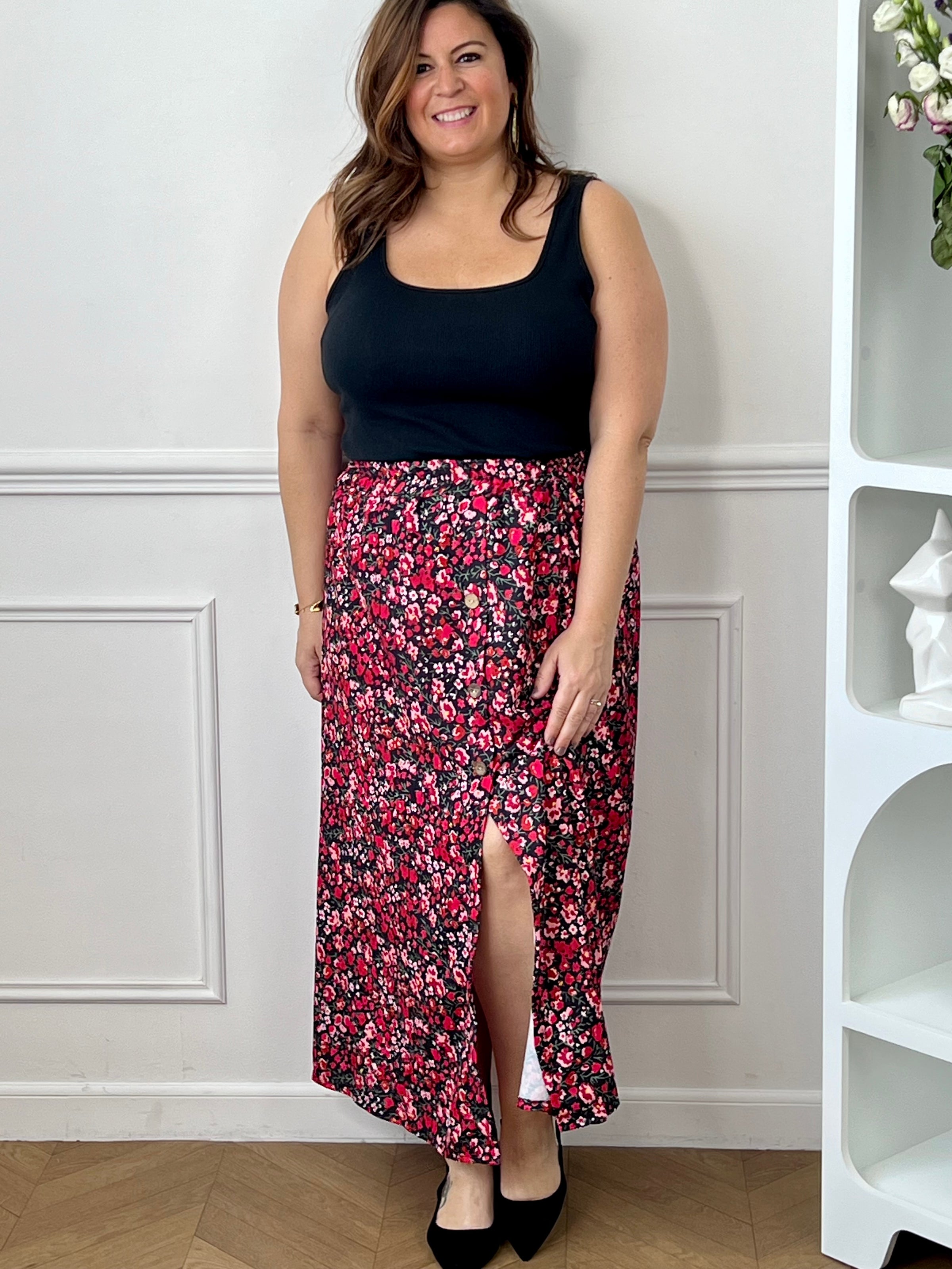 Jupe fleurie noire, rose et rouge à la coupe fluide et féminine. Sa taille élastique assure un confort parfait, tandis que la fente à l’avant apporte une touche légère et élégante.
