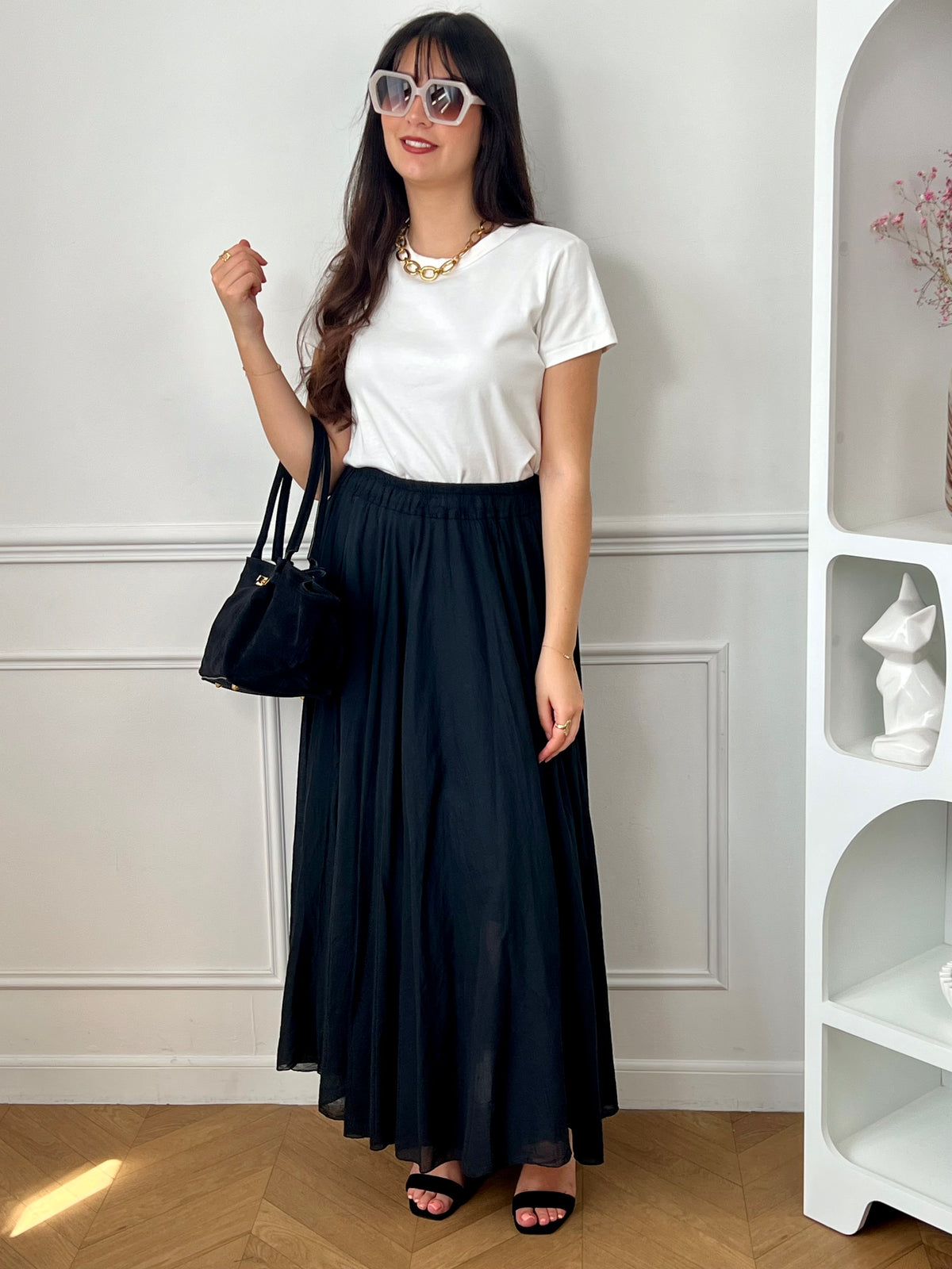 Jupe noire longue femme, légère et agréable à porter, parfaite pour un look élégant au quotidien. Dotée d’une taille élastique, elle assure un confort optimal et s’adapte facilement à la silhouette. Sa doublure jusqu’à mi-longueur garantit une bonne opacité, tandis que sa légère transparence apporte une touche féminine et raffinée. Confectionnée en 100% coton, cette jupe noire est un basique incontournable.