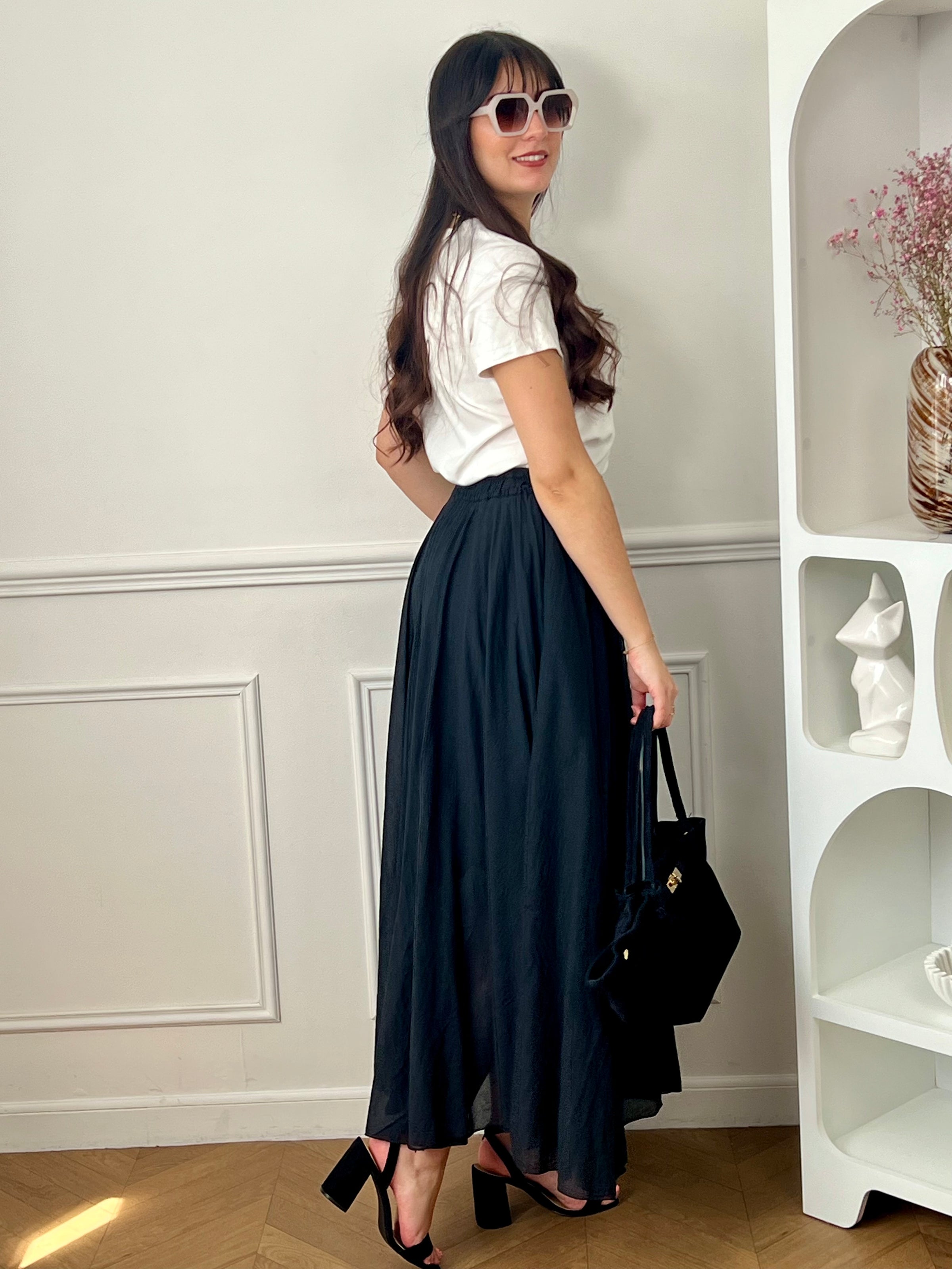 Jupe noire longue femme, légère et agréable à porter, parfaite pour un look élégant au quotidien. Dotée d’une taille élastique, elle assure un confort optimal et s’adapte facilement à la silhouette. Sa doublure jusqu’à mi-longueur garantit une bonne opacité, tandis que sa légère transparence apporte une touche féminine et raffinée. Confectionnée en 100% coton, cette jupe noire est un basique incontournable.